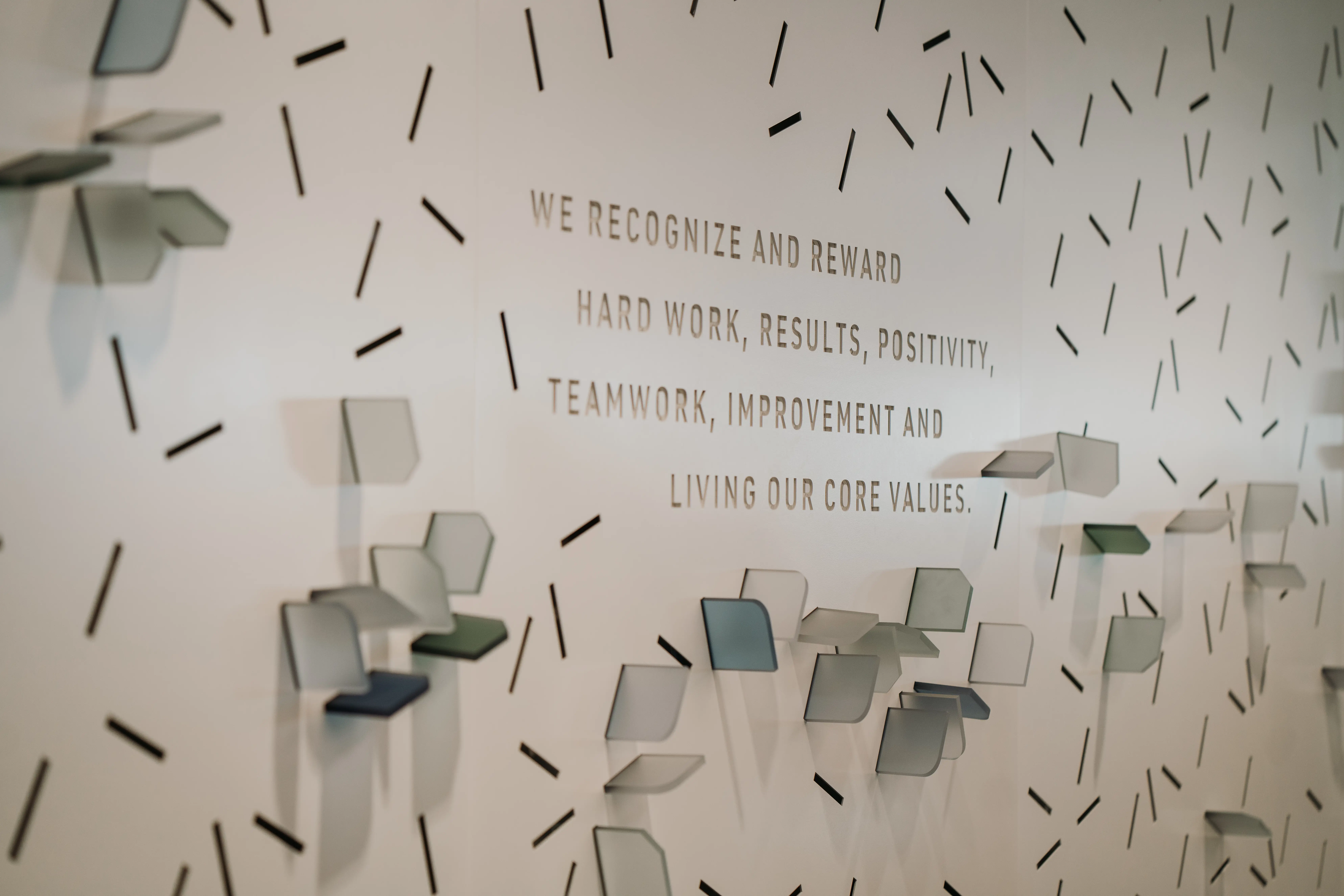 Wall with Quote "We Recognize and Rewqard Hard Work, Results, Posivity, Teamwork, Imporvement, and Living Our Core Values"